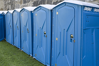 row of blue standard portable toilets